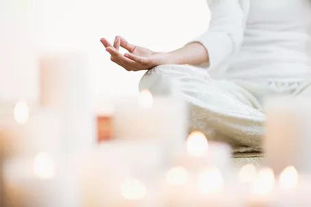 Person meditating with candles